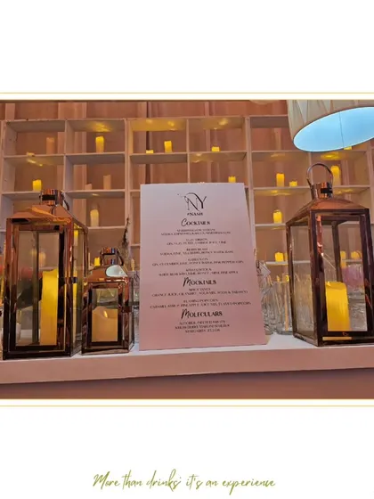 An elegant bar setup featuring a wall of candles that creates a warm, romantic glow. This design is ideal for intimate weddings or upscale evening events.