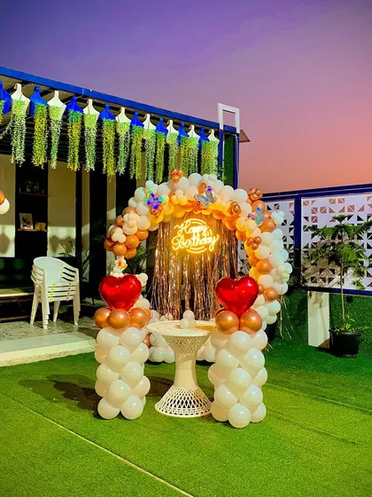 A beautiful twilight shot of the outdoor terrace setup. The glowing neon sign and the sunset in the background make for a truly magical birthday evening.