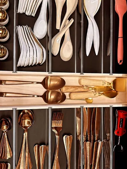A stunningly organized cutlery drawer with gold and wooden utensils. Using dividers keeps every category separate and creates a visually pleasing, functional space.