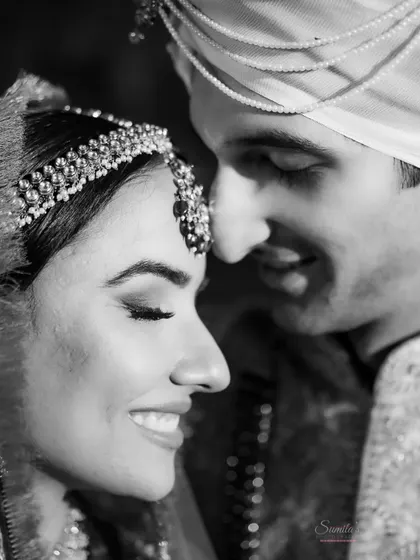 An intimate black and white close-up, capturing the gentle smiles and closeness of the bride and groom. This timeless style emphasizes the emotion of the moment.
