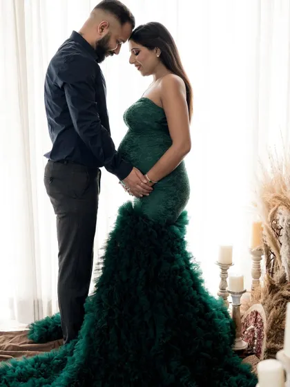 An intimate silhouette of an expecting couple against the soft light of a window. This pose highlights their connection and the beautiful shape of the baby bump.