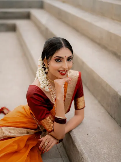 A joyful, relaxed portrait. The bride is lying on steps, looking directly at the camera with a bright smile, creating an engaging and happy image.