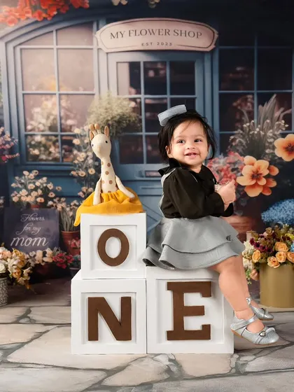 Sitting proudly next to her "ONE" blocks in the flower shop. This photo beautifully combines a milestone marker with a lovely, detailed backdrop.