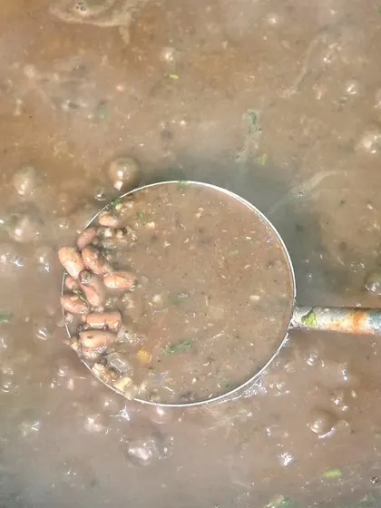 A ladle showing a bean curry, another example of the variety in our main course offerings.