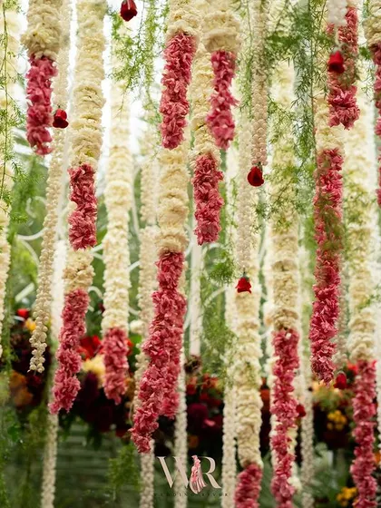A detail shot of the hanging floral garlands, a mix of white tuberoses and red carnations. The texture and fragrance of these traditional flowers added an important sensory layer to the wedding ceremony.