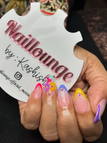 A playful and colorful set with multi-colored French tips and 3D floral accents.