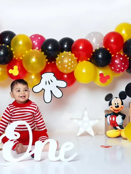 A classic Mickey Mouse first birthday theme, complete with colorful balloons and character props.