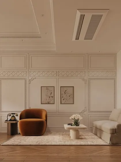 A cozy seating area within the bedroom, featuring a plush velvet armchair in a rich ochre hue. The wall paneling and herringbone wood floors provide a classic, textural foundation for the room's modern and vintage elements.