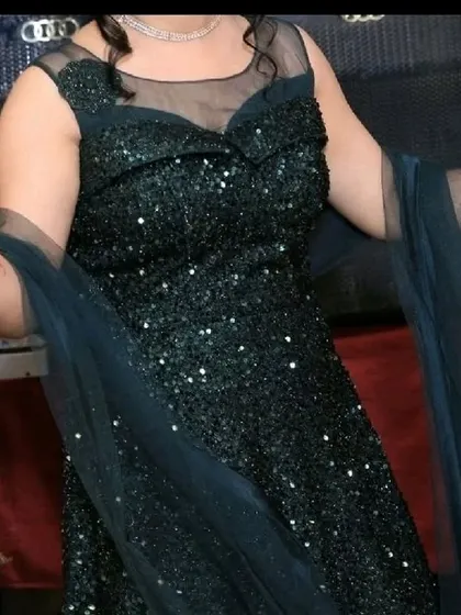 A closer look at the bodice of our green sequined gown, which features a sheer neckline for an elegant touch.