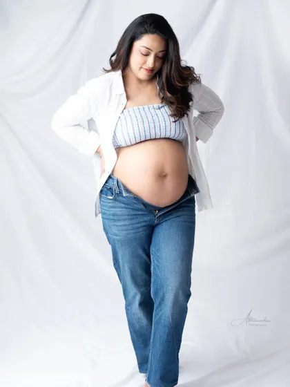 A classic maternity pose. The mom-to-be cradles her bump in this simple and beautiful portrait, highlighting the amazing journey of motherhood.