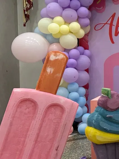 A close-up of a giant pink popsicle prop, adding a fun and whimsical touch to a candyland themed event.