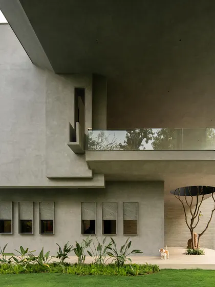 This New Delhi farmhouse, conceived as a private gallery, is a study in monumental forms. The design explores a subtle brutalism, using the raw tactility of concrete to create a powerful dialogue between the structure and the surrounding nature.