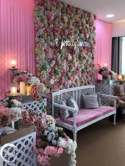 A wider view of the pink-themed Mehendi, showing how the flower wall, seating, and side floral arrangements all work together to create a fully immersive, romantic environment.