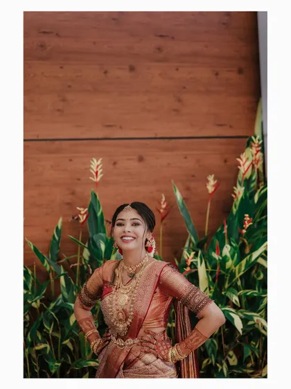 A joyful and confident bridal portrait against a backdrop of tropical plants.
