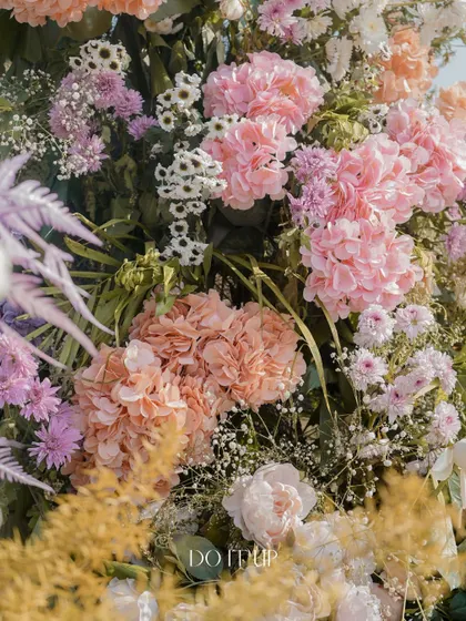 A dense, textured mix of pastel flowers, including hydrangeas, roses, and baby's breath. This style of arrangement creates a soft, cloud-like effect that is incredibly romantic.