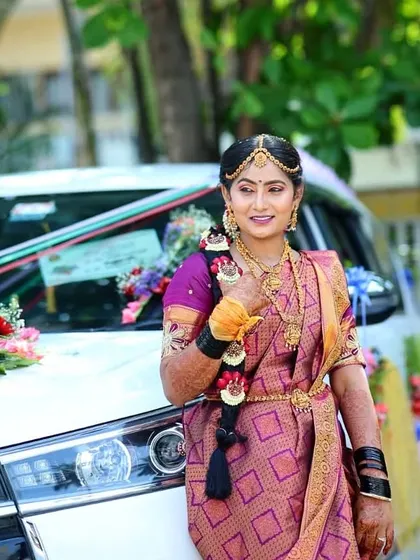 Posing by the wedding car, this bride is ready for her big entrance. Her traditional gold jewelry is perfectly complemented by the makeup.