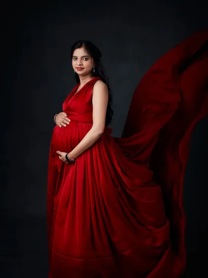 We use fabric tossing techniques to add movement and drama to your photos. This shot captures a bold red gown in motion against a classic dark backdrop.