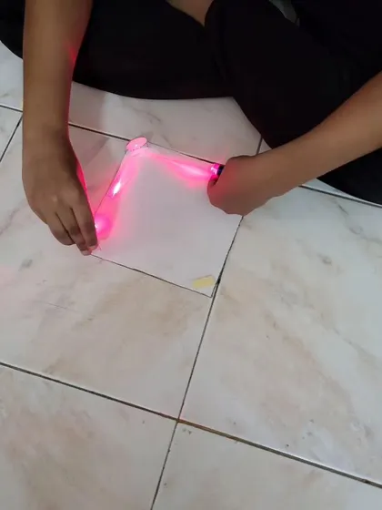Creating a laser security system. A student carefully positions a laser to create a perimeter, learning about the properties of light and basic optics.