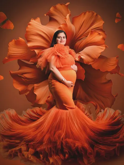 A vision in orange. This portrait features a stunning orange gown that blends into a large, artistic flower backdrop, creating a vibrant and cohesive artistic statement.