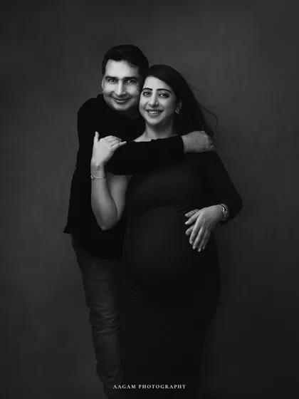 A happy and classic couple's maternity portrait, translated into beautiful monochrome. The black and white format adds a timeless quality to their joyful expressions.