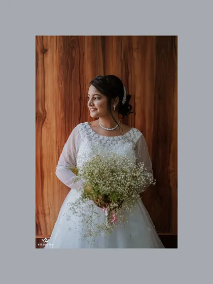 A classic portrait of the bride holding her bouquet, her smile radiating pure joy and anticipation.