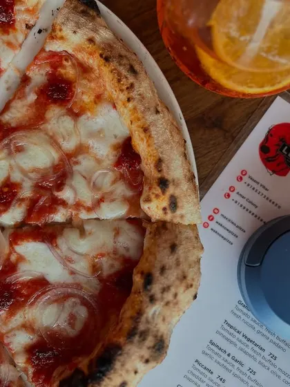 The perfect solo date: our Goan Sausage pizza, a refreshing drink, and your favourite tunes.
