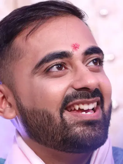 A candid, upward-looking shot of the groom. The makeup is flawless even in close-ups, ensuring a photo-ready finish.