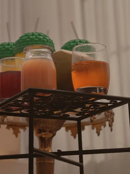 A selection of colorful mocktails and juices, presented on an ornate stand. We ensure our beverage stations are as visually appealing as they are refreshing.