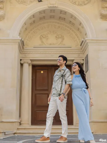 A chic, urban shot of a couple holding hands in front of classic European-style architecture in Baku. This shows the versatility of a destination shoot, combining natural and city environments.