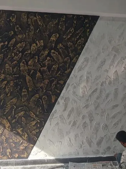 A dramatic, high-texture wall design in progress, featuring a diagonal split between a dark, rugged stone effect and a lighter, softer texture.