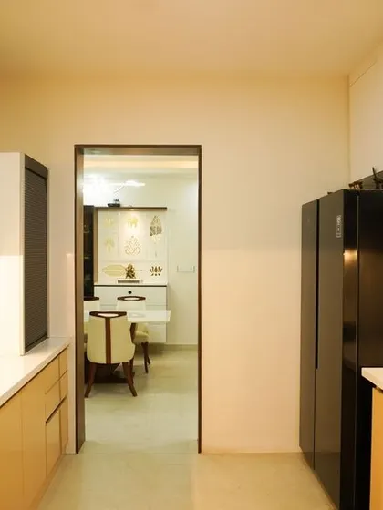 This view of the parallel kitchen shows the placement of the refrigerator and the seamless integration of handleless cabinets. The layout is perfect for maximizing storage and workflow in a narrow space.