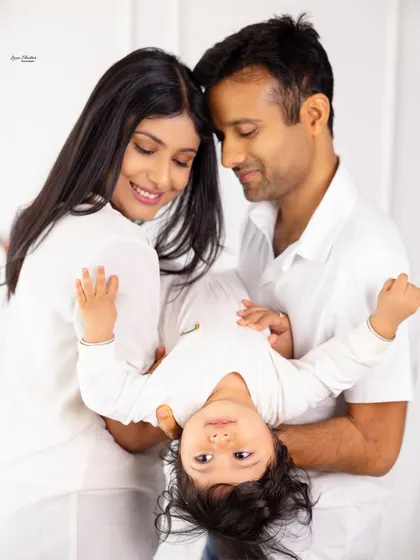 A playful family moment with the parents holding their baby upside down, resulting in a priceless expression. This shows the fun I have with families during sessions.