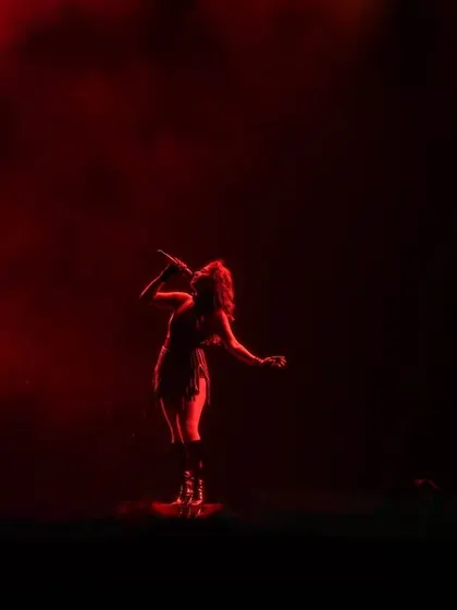 A single artist, a single spotlight, a sea of red. We use dramatic lighting to create intimate, powerful moments even in a massive stadium.