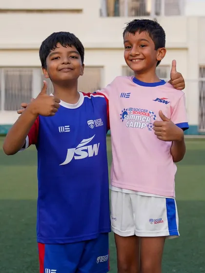 Thumbs up for friendship and football! Two young players, one in a Summer Camp jersey, pose together.