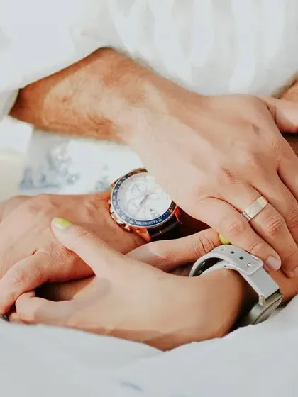 An intimate detail shot of a couple's hands and watches during their pre-wedding shoot, symbolizing their time together.
