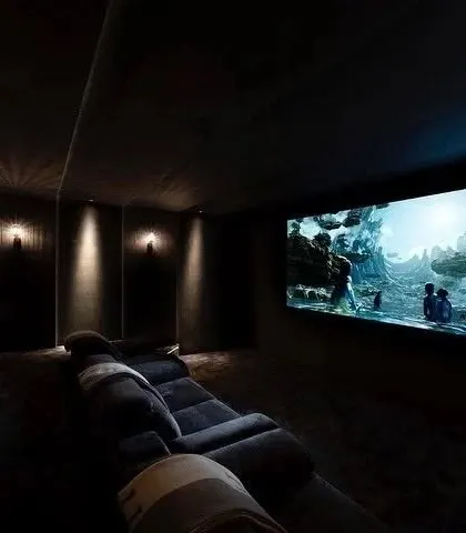 A dark, moody theater where the only light comes from the screen and subtle wall sconces. This setup is ideal for cinephiles who want the most immersive experience possible.