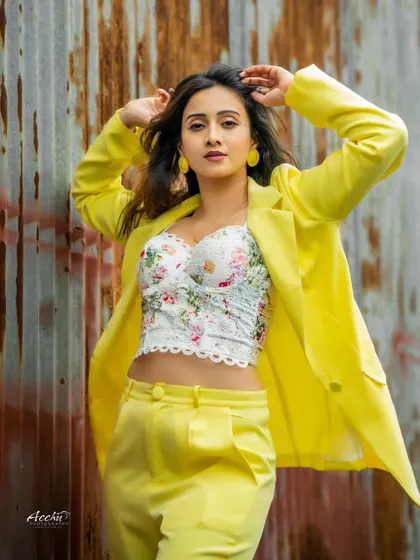 A bold yellow suit against a rustic, corrugated metal wall. This shot is all about contrast, pairing a high-fashion look with a gritty, industrial background for a powerful statement.