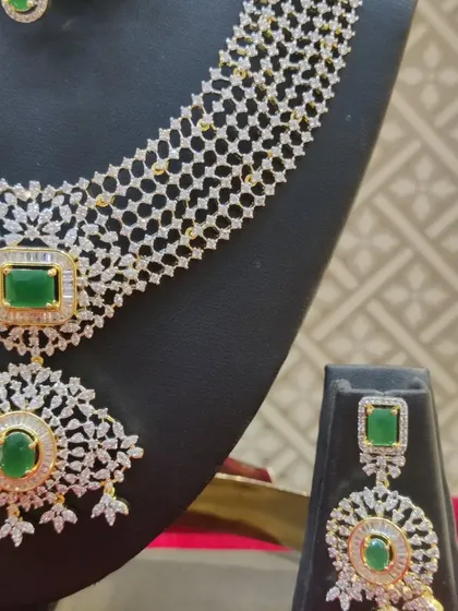 A close-up of the earring and necklace from the emerald and diamond-look set.