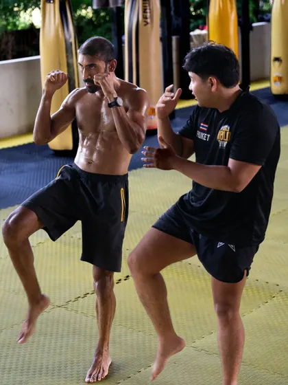 Even as a coach, I'm always a student. Here I am getting coached in Muay Thai in Thailand. To grow, you have to remain coachable and be open to learning new skills.