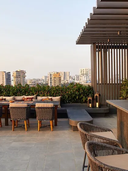 The city-facing side of the terrace includes a bar and dining space, designed with resilient outdoor furniture and strategic landscaping.