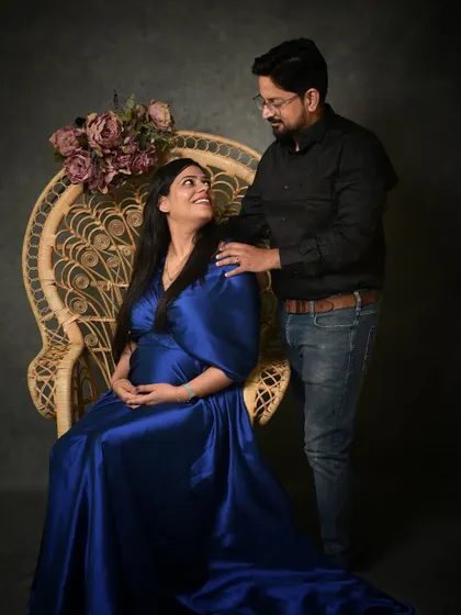 A classic seated portrait in a peacock chair, which adds a touch of bohemian elegance. The interaction between the couple feels natural and loving, making for a timeless image.