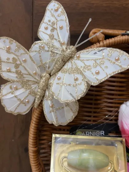 A delicate butterfly ornament adds a touch of whimsy and elegance to this Rakhi gift basket.