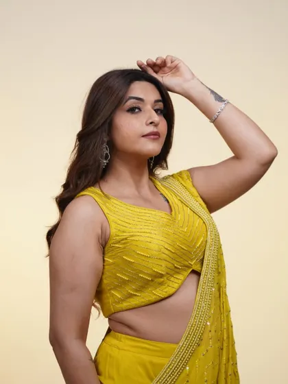 A close-up shot of the yellow draped saree, showing off the flattering cut of the blouse and the delicate fabric.