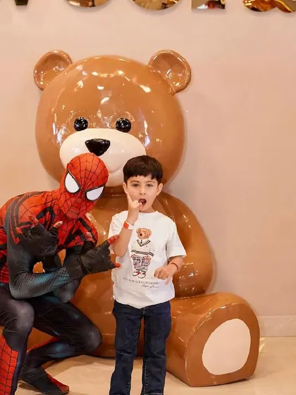 Spider-Man poses with a young fan in front of our giant teddy bear mascot.