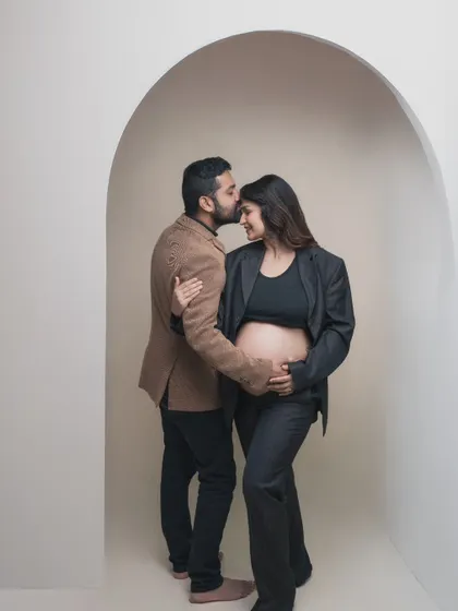 In the warmth of this tender moment, we captured not just a photo but the essence of love and expectation, framed beautifully within a modern archway.