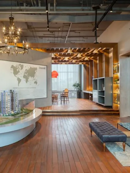 A different angle of the Emaar DigiHomes centre, showing the warm wooden flooring and industrial-style chandelier. The design blends rustic charm with modern luxury to create a unique and welcoming atmosphere.