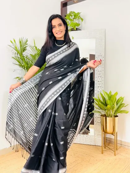 This black khadi cotton saree is a classic piece with a twist. The woven motifs add texture and interest, making it a great choice for a smart workwear look.