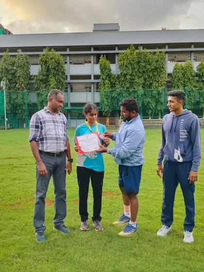 A coach presenting an athlete with her certificate for her outstanding performance in distance running events.