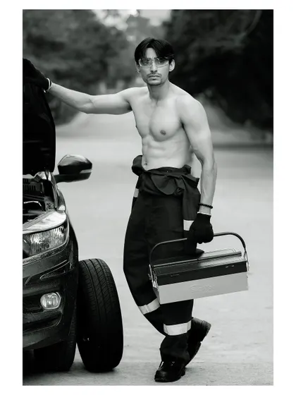 A conceptual men's fitness portrait. The black and white treatment accentuates the subject's physique and the gritty, determined mood of the shot.