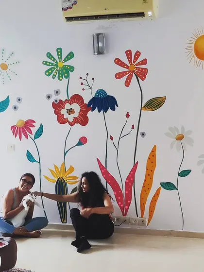 A fun moment with the client and her cat in front of the colorful floral wall.